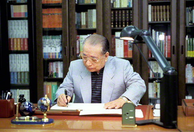 ペンを走らせる池田先生（1999年3月、東京・八王子で）。先生はつづっている。「私は生涯、書き続ける。友のために。広宣流布という、全人類救済の大義のために」と