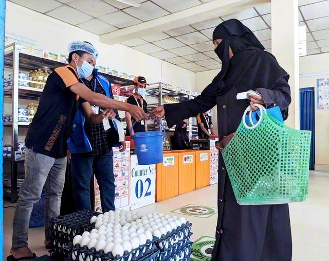 バングラデシュの難民キャンプで食料引換券を使い、配給を受ける女性（2023年）　©WFP/Lena　von　Zabern　　
