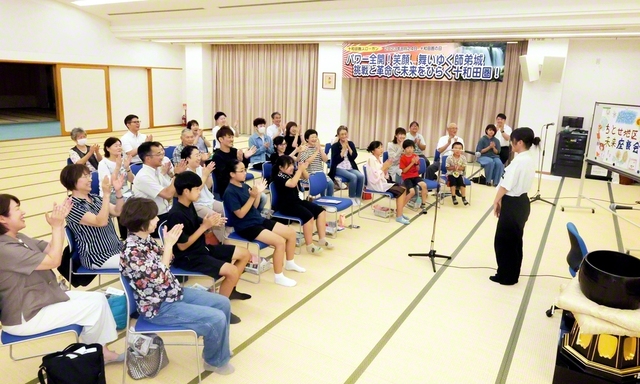青森・ちとせ地区の未来座談会では未来部員の発表に参加者の笑顔がはじけた。「ちとせ地区　未来座談会」との設営物は未来部の友の手づくり（十和田文化会館で）