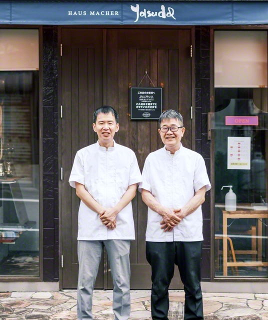 おしゃれな外観の「グルメロード安田」の前で、安田さん親子がにこやかに（左が修さん、右が父・功さん）