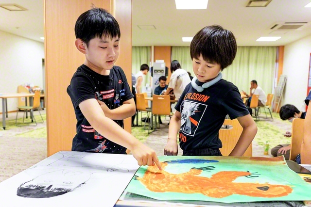 「うまく描けてるね！」――お互いに絵を見せ合う少年部員たち