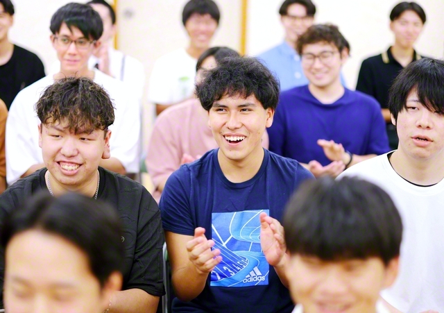 日本語による活動報告にも、今では皆と同じタイミングで笑い、拍手を送るディエゴさん（中央）。「モット信心の体験をツカミタイです！」
