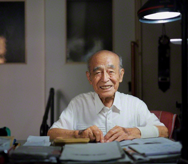 午前9時、机に向かう昭典さん。妻の里代子さん（93歳、支部副女性部長）と暮らしている