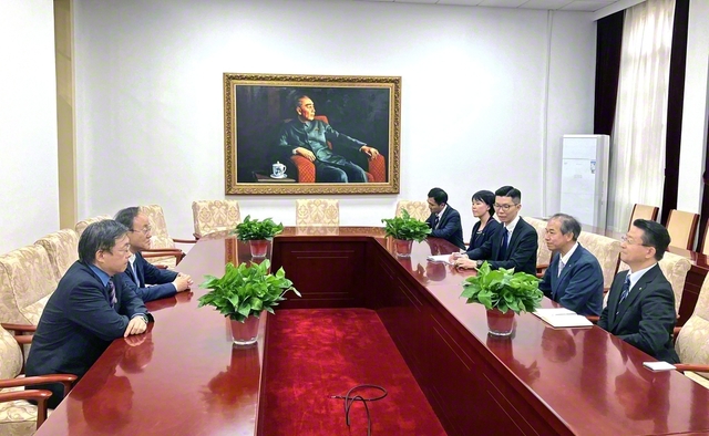 創価学園一行が南開中学の劉浩校長（左奥）と語り合う。周総理の肖像画に見守られて（16日）