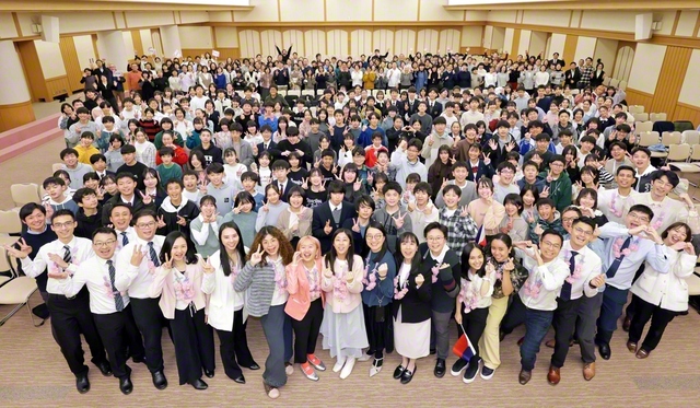 「未来部SGI交流交歓会」に参加した友が記念のカメラに。会合では、富士中学生合唱団が英語で「フォーエバー・センセイ（今日も元気で）」と未来部歌「正義の走者」を披露。勤行の導師やウエルカムスピーチなど、中等部員が主体的に役割を担った。佐藤優子さん（女子中等部）、須山勇希さん（男子中等部）の活動報告、台湾SGIの李世溫（リー・シーウェン）副男子部長の体験発表などの後、SGIメンバーが未来部愛唱歌「勇気の一歩」、「青年よ広布の山を登れ」を日本語で披露し、会場は感動に包まれた（12日、創価文化センター内の金舞会館で）