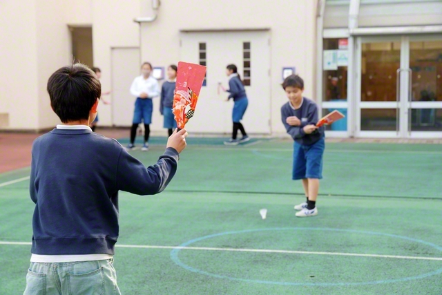 昔遊びの羽根突きに挑戦！　「頑張れ」「ナイス！」――羽根を打ち合うたびに児童たちの仲が自然と深まっていく