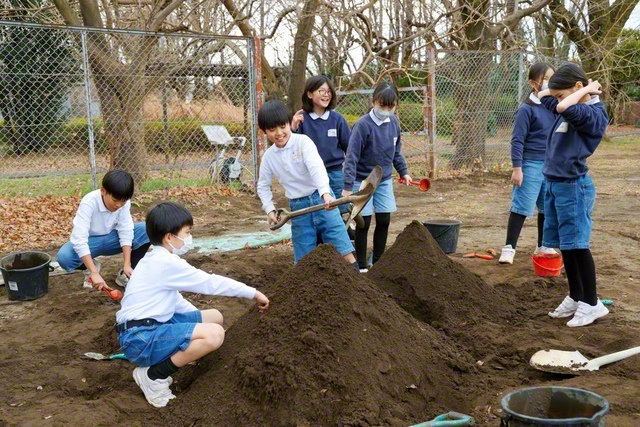 泥遊びに夢中になる児童たち。スコップで砂を掘り、山を作っていると、「ここに穴を掘ってみない？」と、遊びがさらに広がる