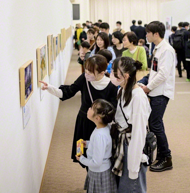 少年少女部員が、家族と共に展示を楽しむ。「どの絵も工夫が凝らされていて感動しました」等の声が寄せられた（創価文化センターで）