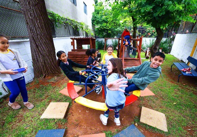 「一緒に遊ぼうよ！」――児童たちが広場の遊具で体を動かす。「遊びは学び」とシルバ校長は言う。「遊びの中で人との関わり方を学び、つながる喜びを知るのです。その喜びのエネルギーがまた、子どもを新たな学びへ向かわせます」。ユニセフ（国連児童基金）のリポートによれば、外遊びをする子どもほど幸福度が高くなるという