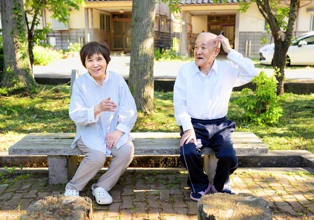 「まいったなー」と頭をかき、ほんわかとした雰囲気をまとう田仲さん㊨。妻の範子さん㊧とのかけ合いには、楽しい響きがあふれる