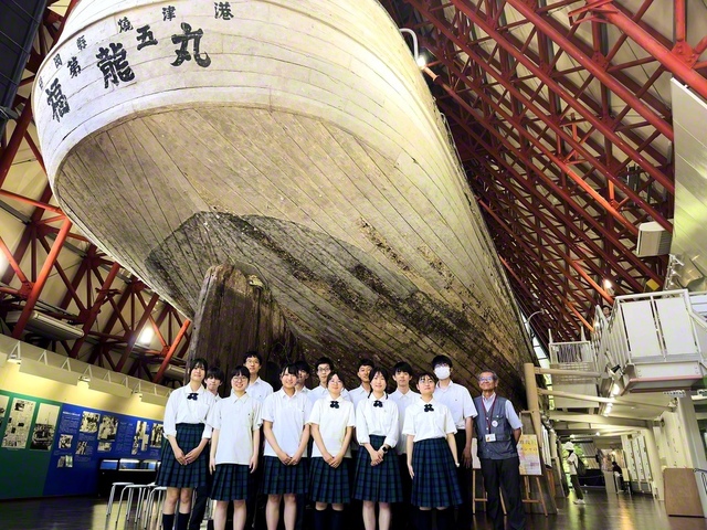 保存・展示されている「第五福竜丸」の実物を背に、参加した生徒らが、平和の心を未来へ継ぐ決意を込めて(28日、第五福竜丸展示館で)