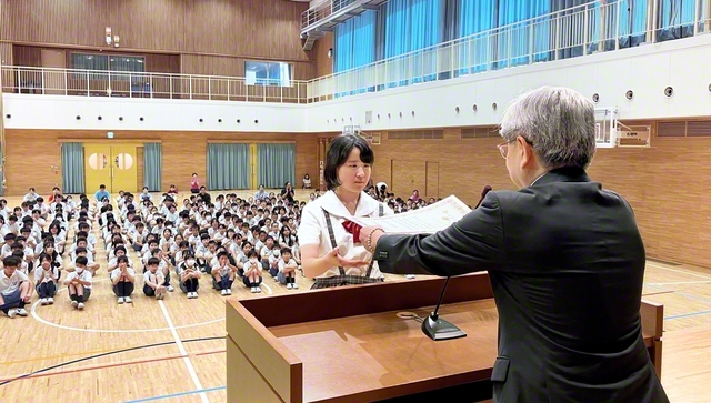 代表の児童に表彰状が贈られた（関西創価小学校で）