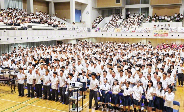 関西中・高合同の式典では、各人の決意などを記した自作のうちわを掲げた（大阪・交野市の関西創価学園・池田講堂で）