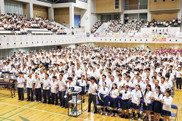 関西中・高合同の式典では、各人の決意などを記した自作のうちわを掲げた（大阪・交野市の関西創価学園・池田講堂で）