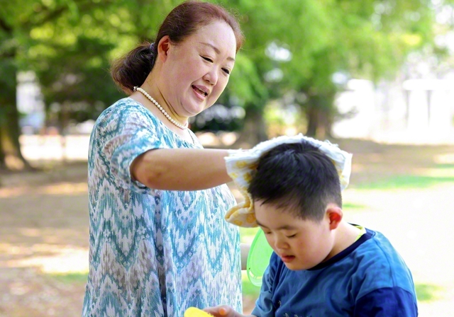 ダウン症の次男・光弘さん㊨の汗を拭く齋藤さん。「この子の笑顔が見たいから、家族みんなが仲良く団結できるんです」と