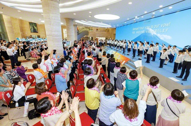 少年少女部「日の出合唱団」の心を込めた歌声に、皆が立ち上がって拍手と歓声を。池田先生が切り開いた平和の大道に連なる誓いにあふれる研修会が幕を開けた（ソウルの池田記念講堂で）