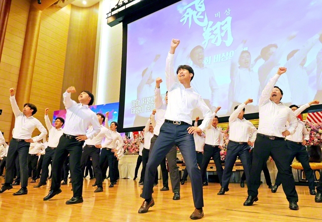 韓国全土の圏男子部長120人が、学会歌「紅の歌」の指揮を力強く。渾身の姿に決意の波動が広がった（同）