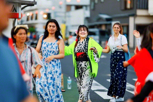 観光客と一緒に踊る上野さん。アメリカ人女性の住まいは、上野さんの留学先と同じ地域だった。「全てに意味があると、今なら思えます」と笑顔がはじける