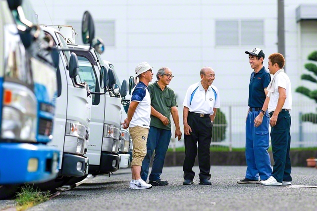 配送から戻った社員らと語り合う実原さん（中央）