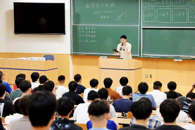 学生部の教学実力試験の受験者たちを森薗学生部長がたたえた(創価大学で)