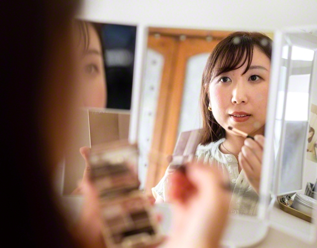 真央さんは、メークブラシでパレットから色をすくい、手の甲で余分をはらった。鏡に顔を寄せ、まぶたをそっとなぞる。それはただの装いではない。誰かを幸せにする準備