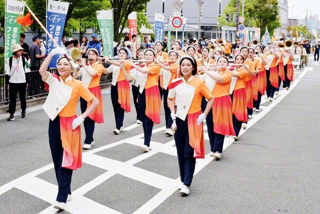 創価関西Joshoサウンズ（上、立石一成楽団長）と、関西富士鼓笛隊（下、三好英梨子部長）が笑顔で（大阪・豊中市内で）