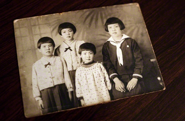 戦前に写真館で撮影した一枚（右から姉・邦子さん、次妹・靖代さん、清水さん、長妹・美稔子さん）。「父が作ってくれたミカン水を、みんなで飲みよったよ」。4姉妹で過ごした夏の思い出がよみがえる
