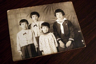戦前に写真館で撮影した一枚（右から姉・邦子さん、次妹・靖代さん、清水さん、長妹・美稔子さん）。「父が作ってくれたミカン水を、みんなで飲みよったよ」。4姉妹で過ごした夏の思い出がよみがえる