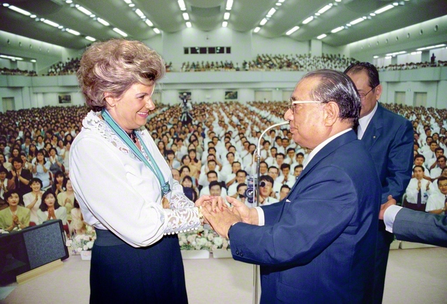 本部幹部会の席上、サイフェルト氏と握手を交わす池田先生（1991年8月24日、札幌市の北海道池田講堂で）