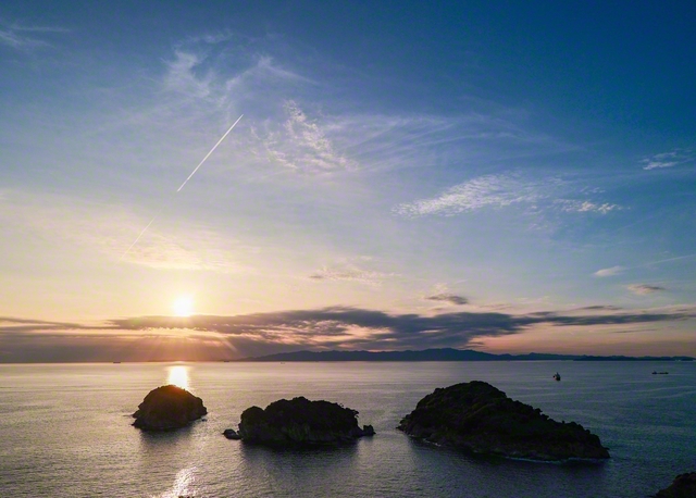 雄大な海岸線が広がる雑賀崎（和歌山市）。夕空に飛行機雲が伸びていく＝和歌山・藤原二美通信員