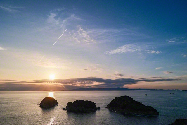 雄大な海岸線が広がる雑賀崎（和歌山市）。夕空に飛行機雲が伸びていく＝和歌山・藤原二美通信員