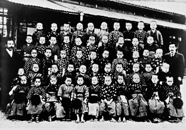 校長として初めて赴任した東盛尋常小学校で、児童と記念撮影する牧口先生（3列目の右端）