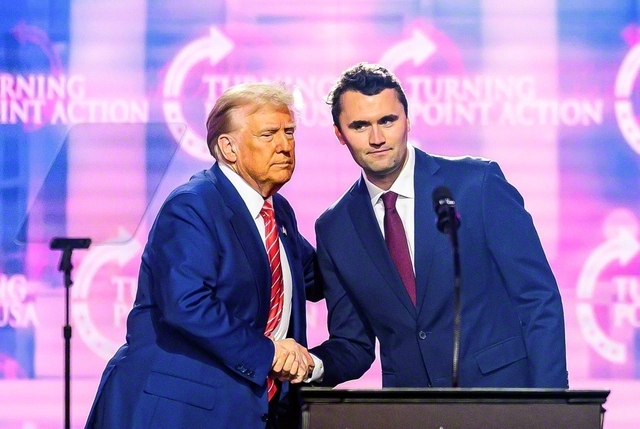 昨年12月、米南西部アリゾナ州内のイベントで握手を交わすドナルド・トランプ氏㊧と保守活動家チャーリー・カーク氏＝AFP時事