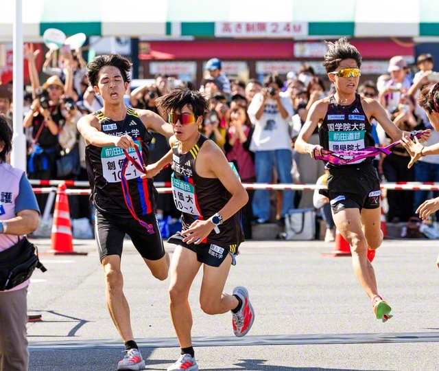 1区・織橋選手㊧から2区・小池選手へ、絶好調の“3年生コンビ”が勝負の前半を駆け抜けた（第1中継所・出雲市役所、JAしまね前で）