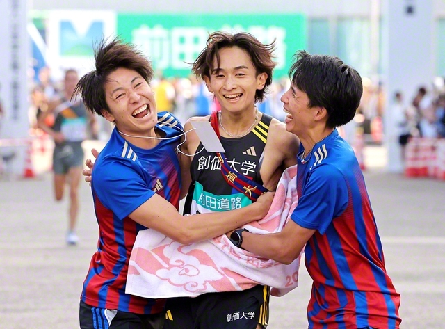 区間5位で6区を走り抜きゴールした野沢選手㊥を仲間たちが出迎えた（出雲ドーム前で）