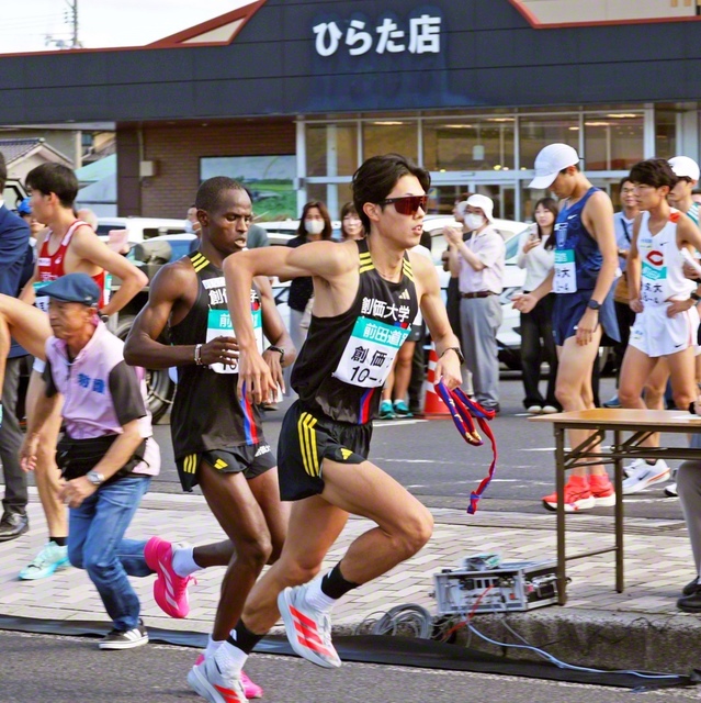 ムチーニ選手㊧からタスキを受け取った4区の石丸選手（第3中継所・JAラピタひらた店前で）