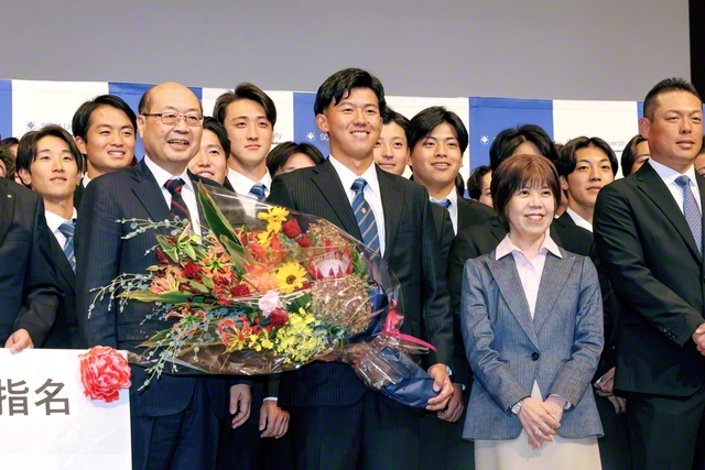 笑顔を見せる創価大学・立石選手(中央)。秋谷創大理事長、鈴木学長、選手らと記念のカメラに