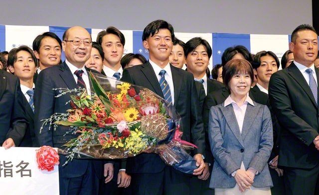 笑顔を見せる創価大学・立石選手（中央）。秋谷創大理事長、鈴木学長、選手らと記念のカメラに