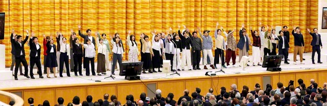 全国人間教育実践報告大会で青年教育者が合唱。小学校教諭の田中大輝さん、保育士の蘆田菜々さんが元気に司会を務めた（北海道池田講堂で）