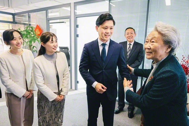 周秉徳氏（右端）と、その子息の沈清氏（右から2人目）が、学会青年訪中団の代表を歓迎（27日、北京市内で）