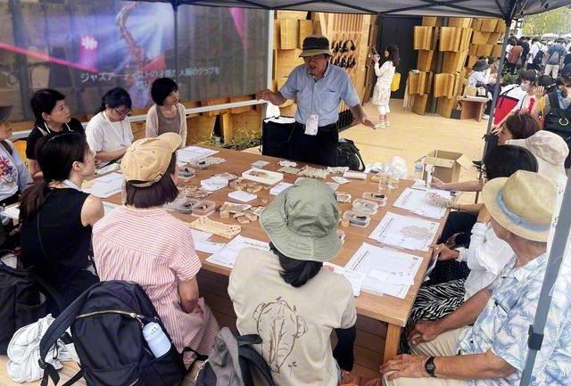 ポーランド館でのワークショップで、天然顔料について解説する橋本さん（写真中央、9月10日）