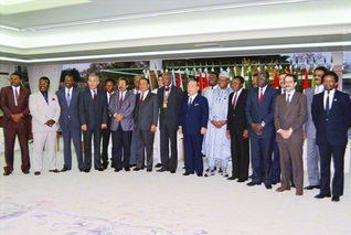 池田先生が授賞式に列席したアフリカ19カ国の大使（大使代理）らと記念のカメラに（1991年11月29日、創価国際友好会館＜当時＞で）。先生は「本日は、大変にありがとうございます。感動の歴史の一日となりました」と感謝を述べ、一人一人と固い握手を交わした