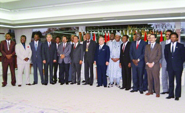 池田先生が授賞式に列席したアフリカ19カ国の大使（大使代理）らと記念のカメラに（1991年11月29日、創価国際友好会館〈当時〉で）。先生は「本日は、大変にありがとうございます。感動の歴史の一日となりました」と感謝を述べ、一人一人と固い握手を交わした