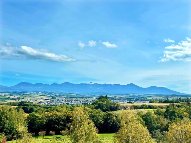 北海道の中央にそびえる十勝岳連峰。火山活動でできた丘陵地が広がる（美瑛町で）