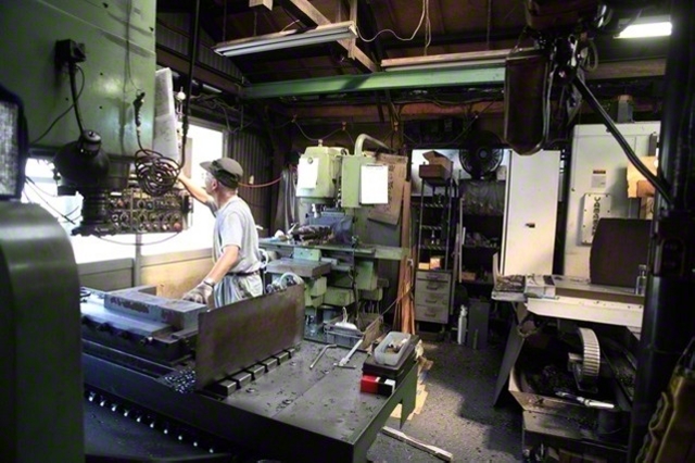 フライス盤を操作し、精密な金属部品の加工に取り組む町工場の職人（Starting　Over/PIXTA）