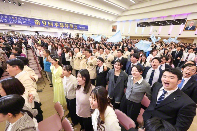 青年こそ世界青年学会の主役！　若き友らが肩を組みながら学会歌「フォーエバー・センセイ（今日も元気で）」を大合唱（東京戸田記念講堂で）