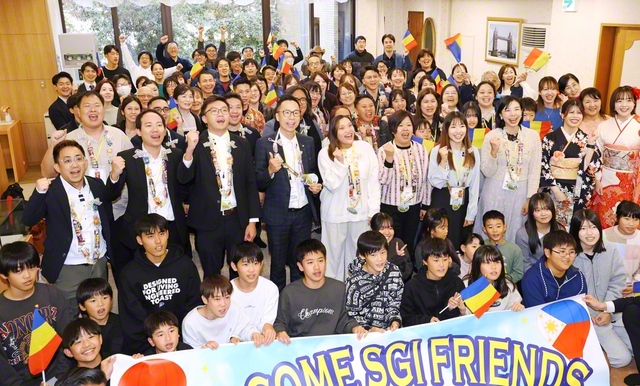 香港、フィリピン、インドネシアと佐賀の同志が記念のカメラに。歓喜があふれた集いでは木下真緒さんが信心根本に社会で奮闘する模様を報告した（佐賀文化会館で）