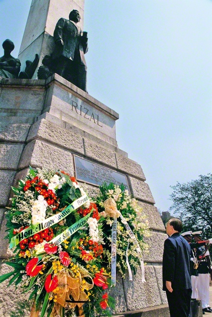 リサール像に花輪をささげ、偉大な英雄の尊き生涯をしのぶ池田先生。儀式では、青空に3発の号砲がとどろき、国花の名を冠した「サンパギータ」の曲が奏でられた（1998年2月9日、マニラ市で）