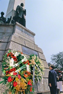 リサール像に花輪をささげ、偉大な英雄の尊き生涯をしのぶ池田先生。儀式では、青空に3発の号砲がとどろき、国花の名を冠した「サンパギータ」の曲が奏でられた（1998年2月9日、マニラ市で）