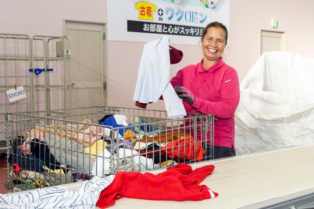 衣類が再利用できるか、スタッフが手作業で確認する